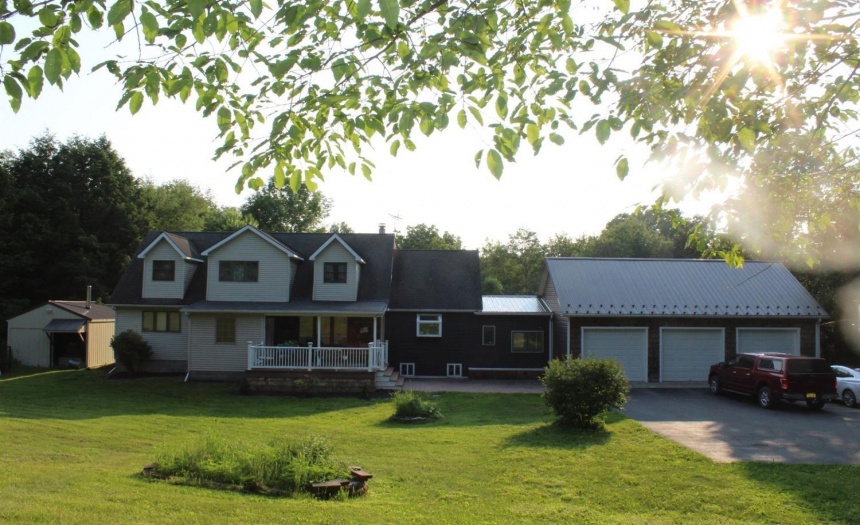 House with Garage to right and wood furnace to left