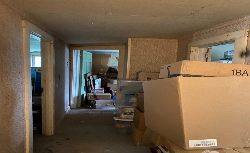 Unfinished area of house, hallway to 3 rooms.