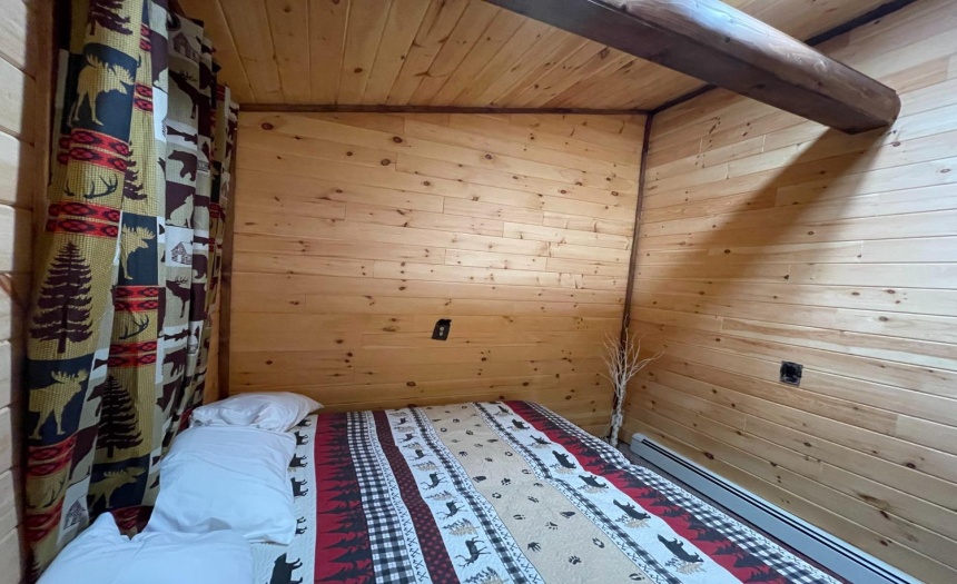 Bedroom with carpet, open beam ceiling design & log walls
