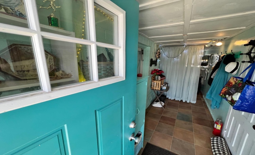 New Pella door into the mud/mechanical room featuring a new ceramic tile floor