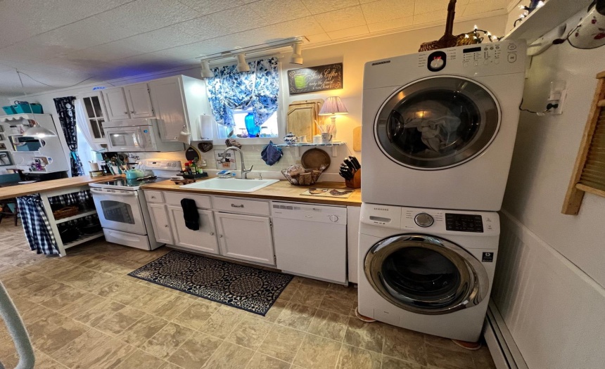 New vinyl floor, butcher block counters and stackable laundry center in the large kitchen.