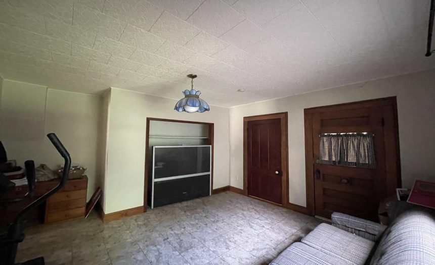 1st floor room with doorway to the front wrap around porch and doorway to the left opens to the front hall entranceway.  This room currently serves as a quiet, private separate tv room, den