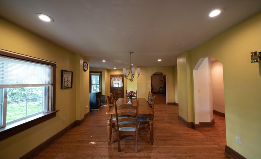 Formal Dining Room.  Door to the front porch is seen in the foreground.  Straight ahead is entrance to the library.  To the right is a center hall.