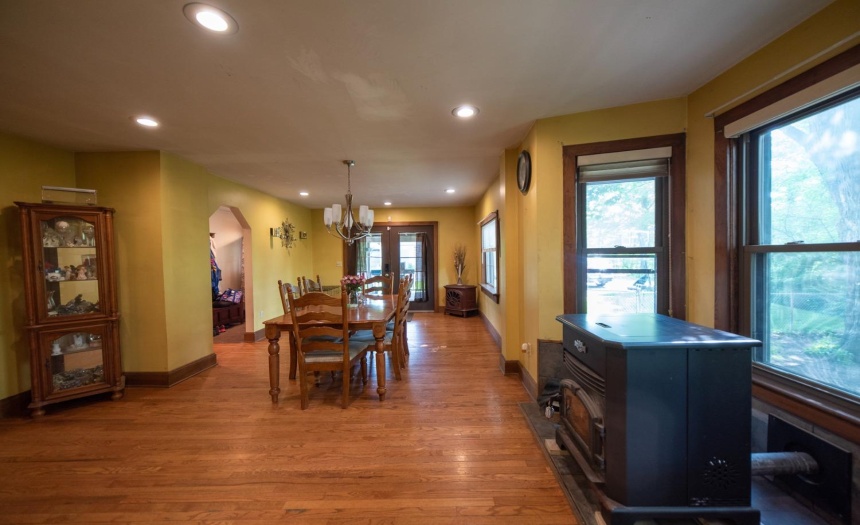 Looking across the formal dining room from the entrance door off the front porch.  Doors in the foreground open onto the covered deck.  Windows to the right overlook the fenced yard.