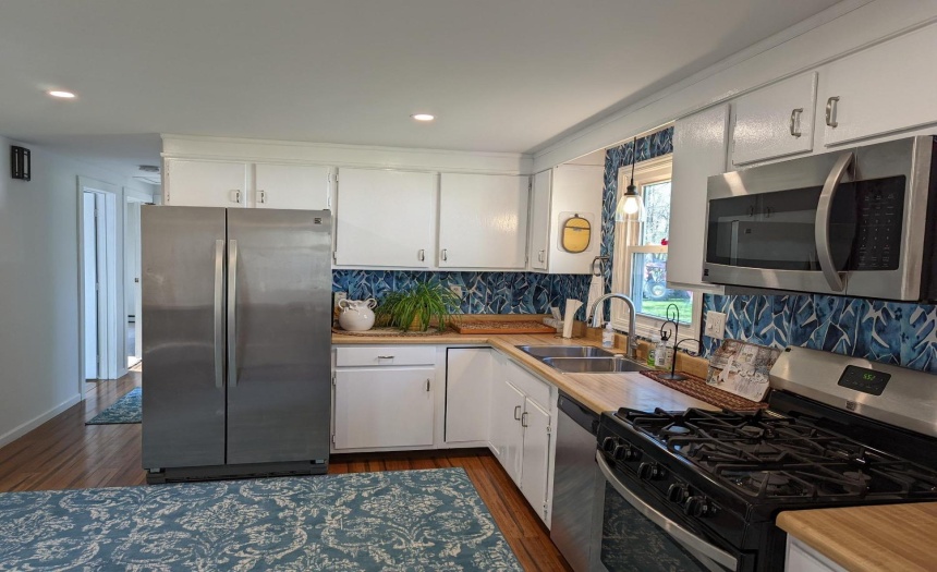 Spacious kitchen with stainless steel appliances, can lighting
