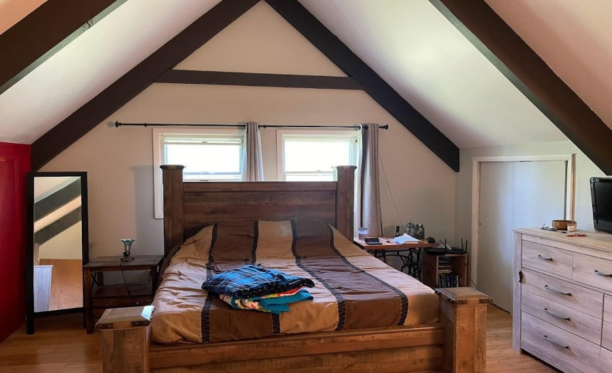 upstairs bed room with bamboo flooring and 3 closets